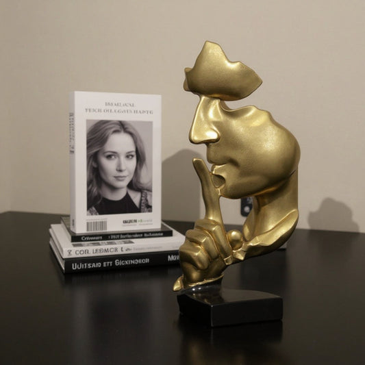 Modern minimalist gold silence face sculpture paired with luxury coffee table books, offering sophisticated mental health aesthetic for high-end home office decor.